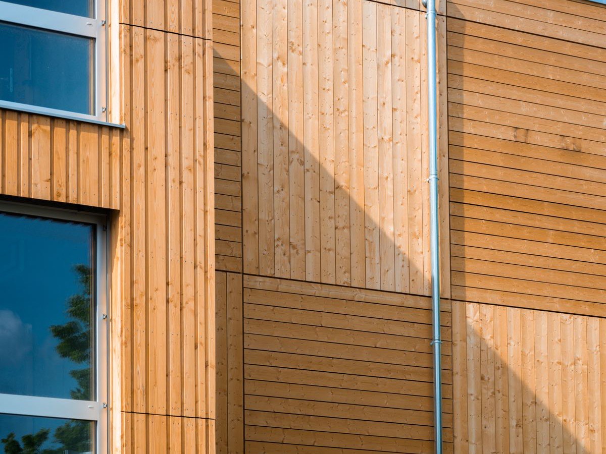 Façade bois associant un bardage vertical à lames jointives et des panneaux horizontaux en claire-voie