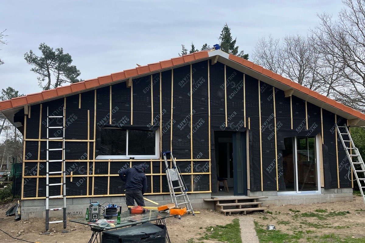 Pare-pluie et tasseaux de contre-lattage posés sur la façade avant la fixation du bardage bois, chantier en Gironde