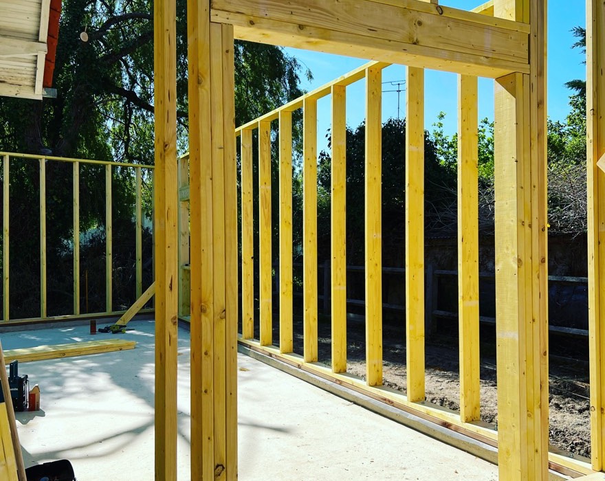 Murs en ossature bois montés sur une dalle béton, ouverture réservée pour la porte, chantier en Gironde