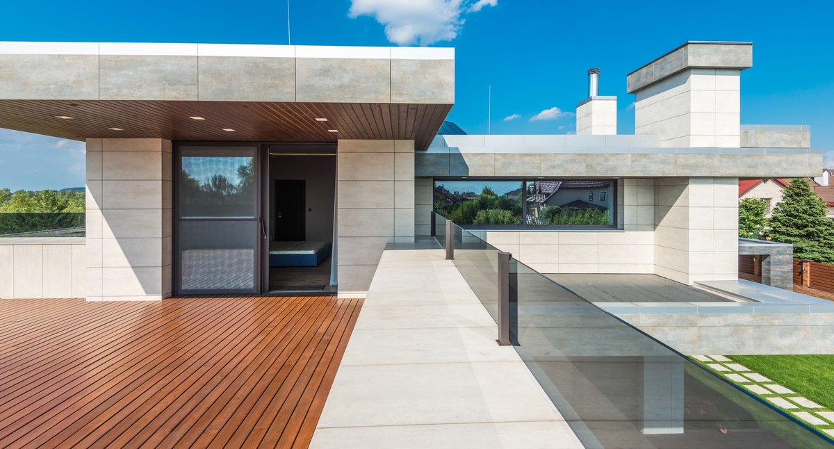 Garde-corps de terrasse surélevée en aluminium à remplissage en verre, sur une terrasse contemporaine en bois