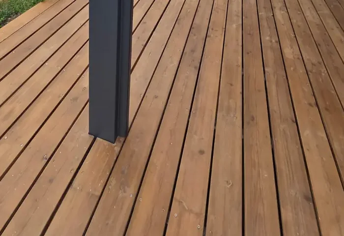 Pied de poteau de pergola aluminium au ras des lames d'une terrasse en bois, Gironde