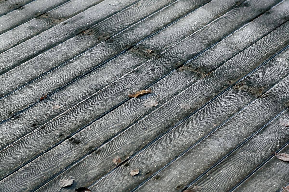 Terrasse en bois vieillie, lames grisées et patinées par les intempéries avant rénovation