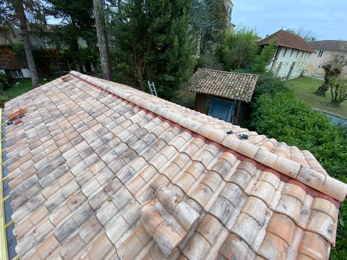 Couverture en tuiles posée sur une construction à ossature bois, vue depuis le faîtage, chantier de L'Esprit Bois en Gironde