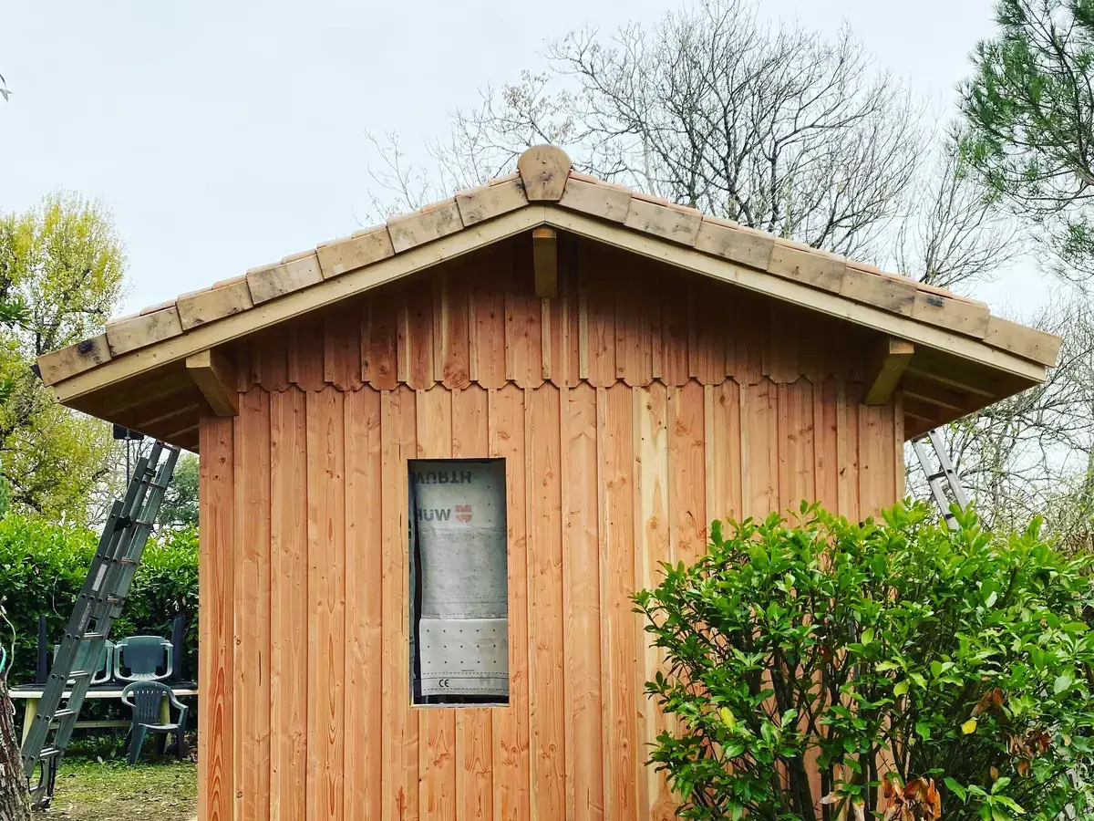Pignon d'une construction à ossature bois achevée, bardage douglas vertical et débord de toiture, chantier de L'Esprit Bois en Gironde