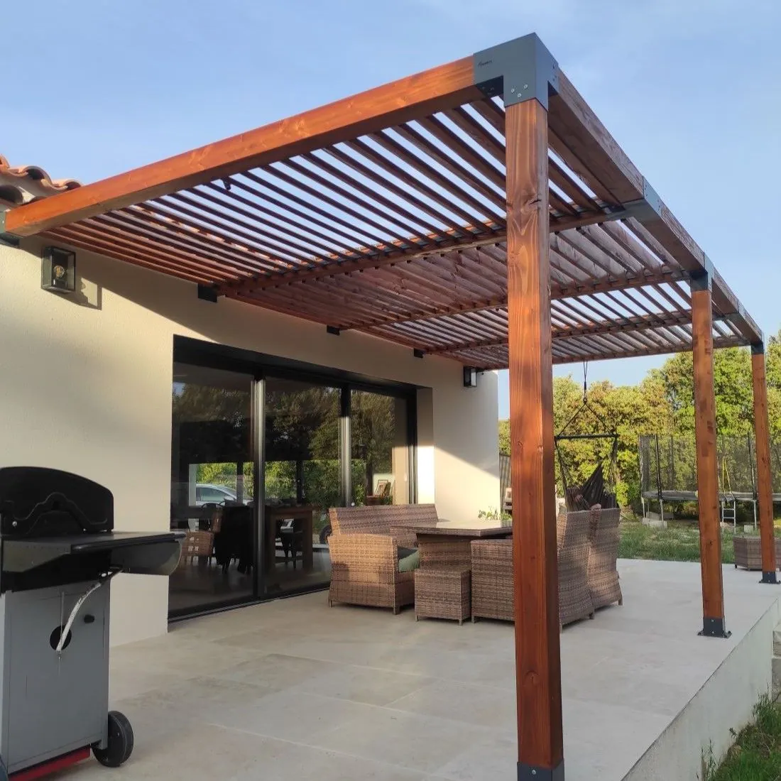 Pergola en bois massif couvrant un salon de jardin sur une terrasse, réalisation à Arveyres