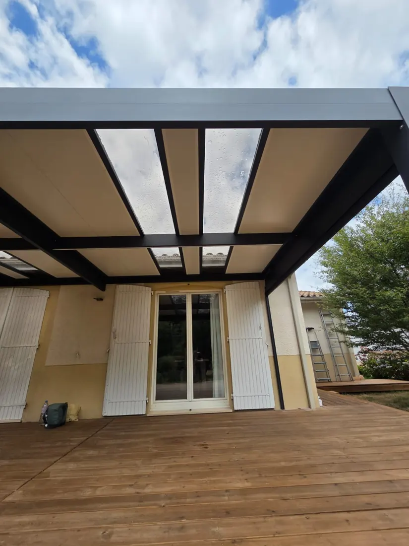 Détail de la couverture en panneau sandwich isolé d'une pergola aluminium adossée à la façade