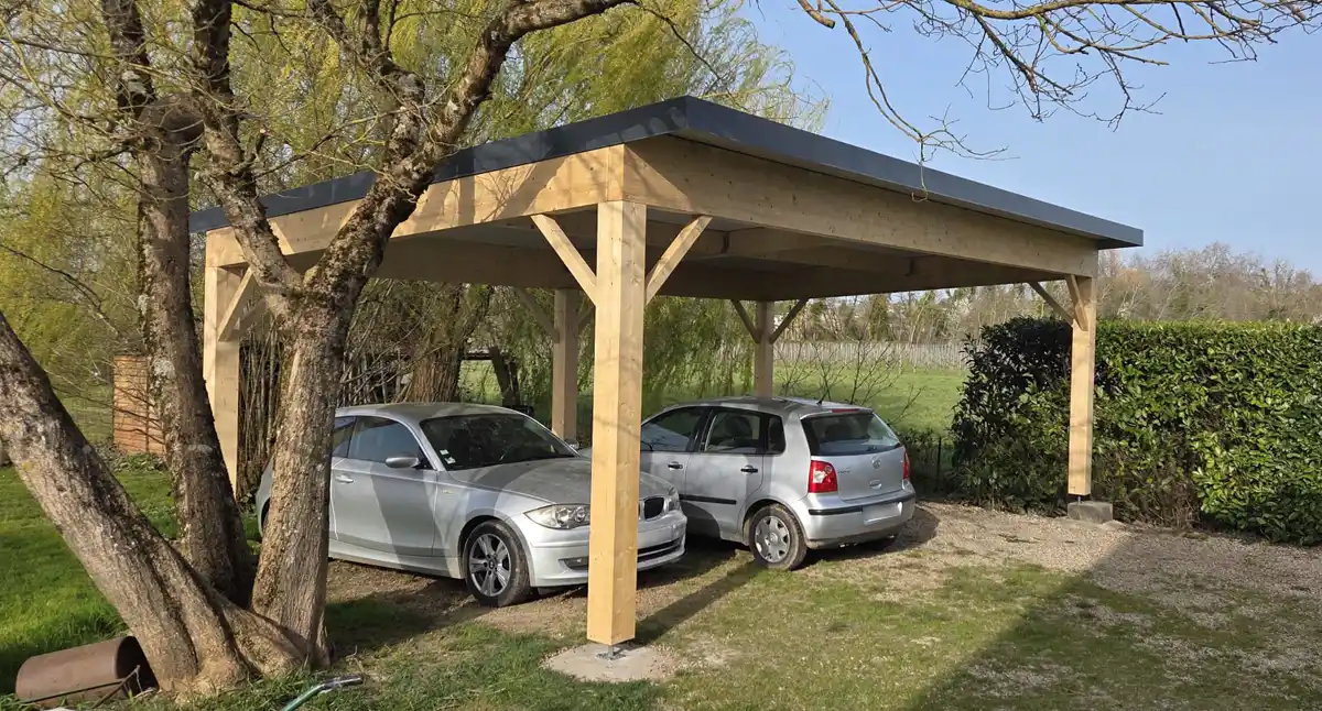 Carport bois deux places à toit plat abritant deux voitures, réalisation en Gironde