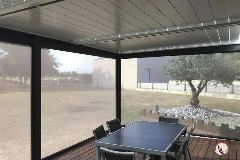 Vue sous une pergola bioclimatique aluminium avec éclairage LED intégré aux traverses et store latéral