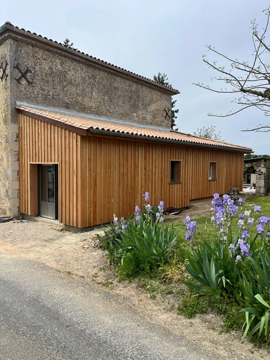 Extension en ossature bois accolée à une maison en Gironde, bardage bois et grandes baies vitrées, près de Libourne