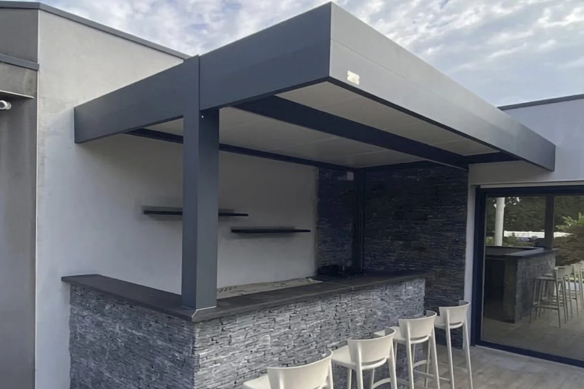 Pool-house équipé d'un bar en pierre et d'une toiture plate en aluminium, réalisation près de Libourne